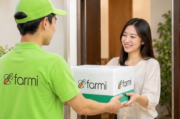 Japanese grocery delivery box and smartphone showing order tracking on a home table in HCMC